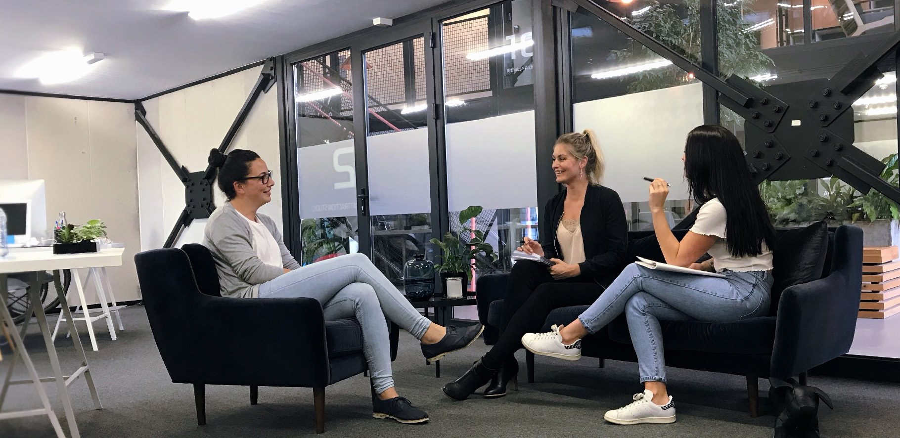 Three people sitting down having a casual meeting
