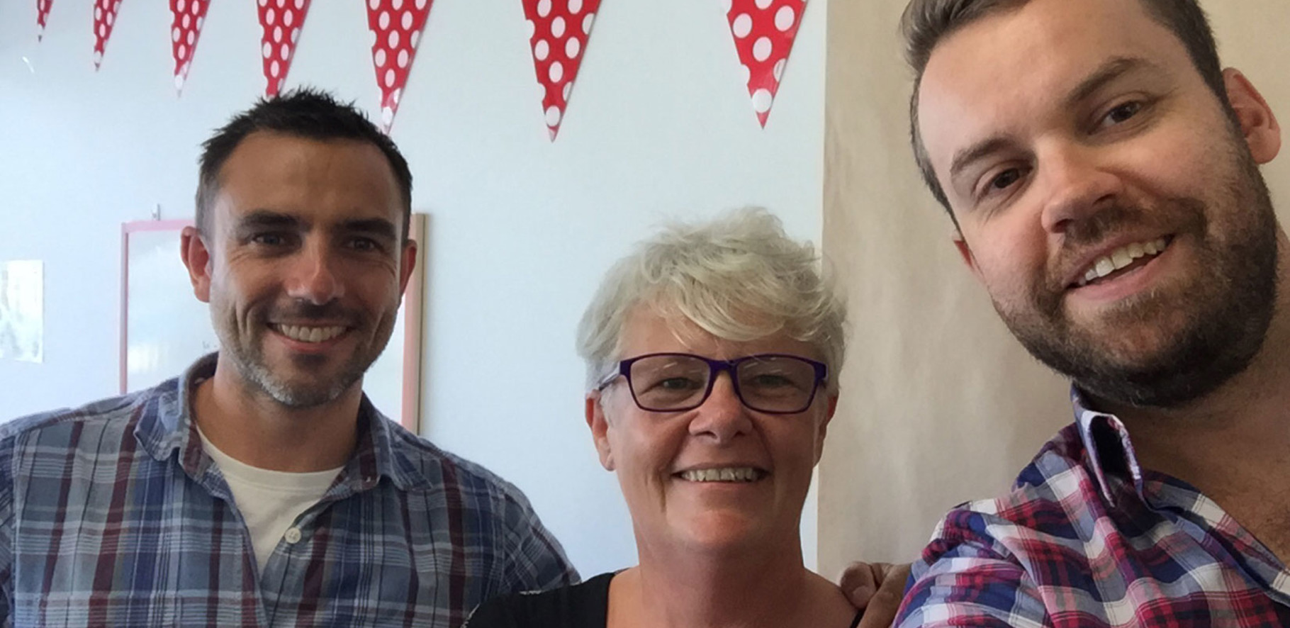 three happy people smiling at the camera taking a selfie