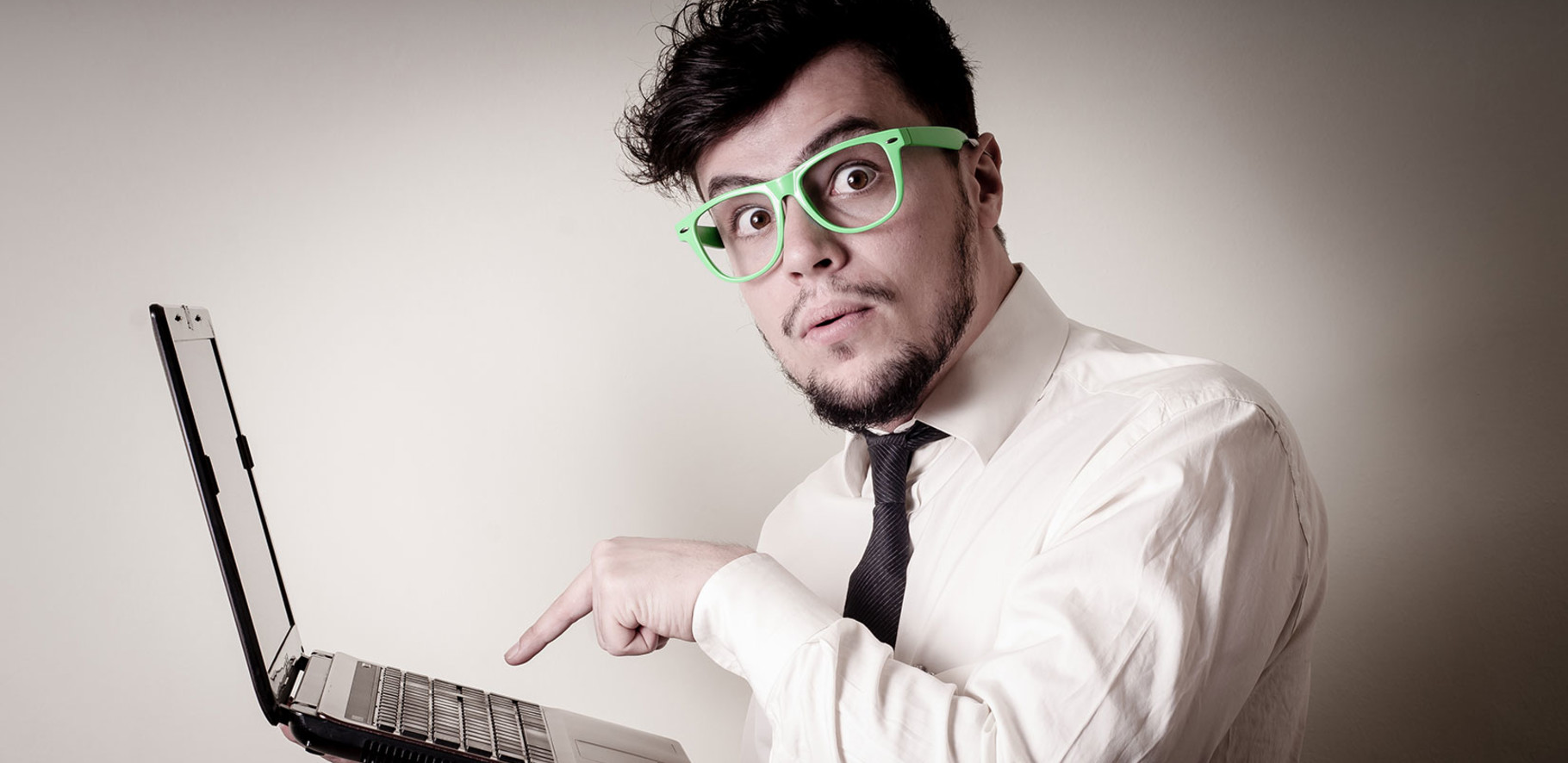a man who is about to push the enter button on a laptop is looking directly at you with an apprehensive look on his face